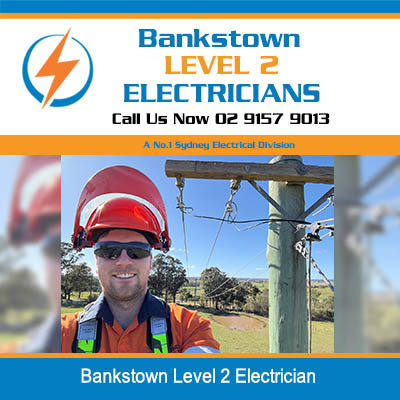 Level 2 electrician in safety gear standing near power pole in Bankstown